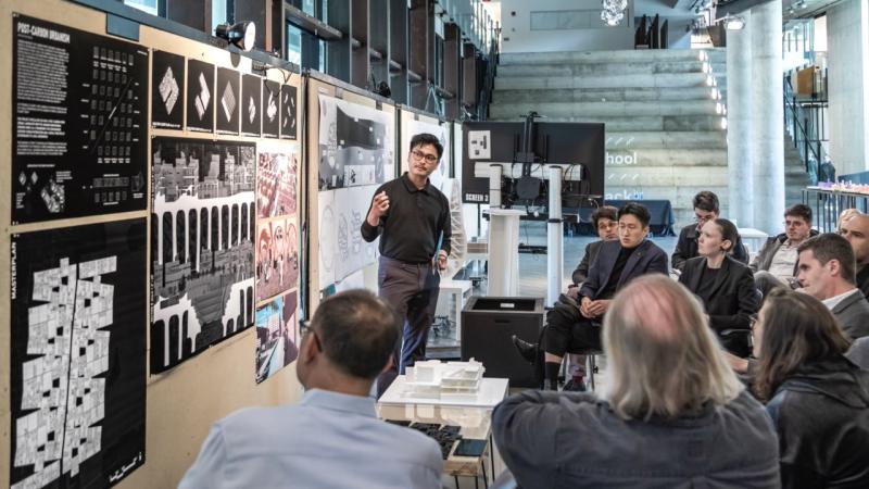 A student presents their work during a review in Knowlton Hall's Center Space