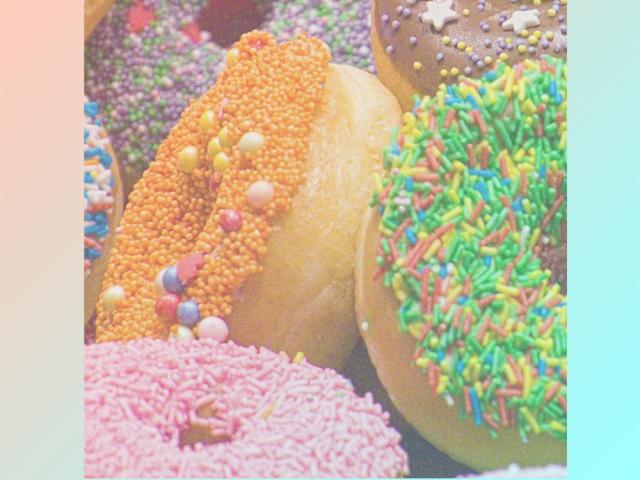 A pile of donuts of rainbow hues