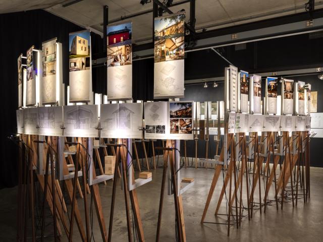 Image of the Biogenic House Section exhibition showing a circle of easels with books displayed on them  
