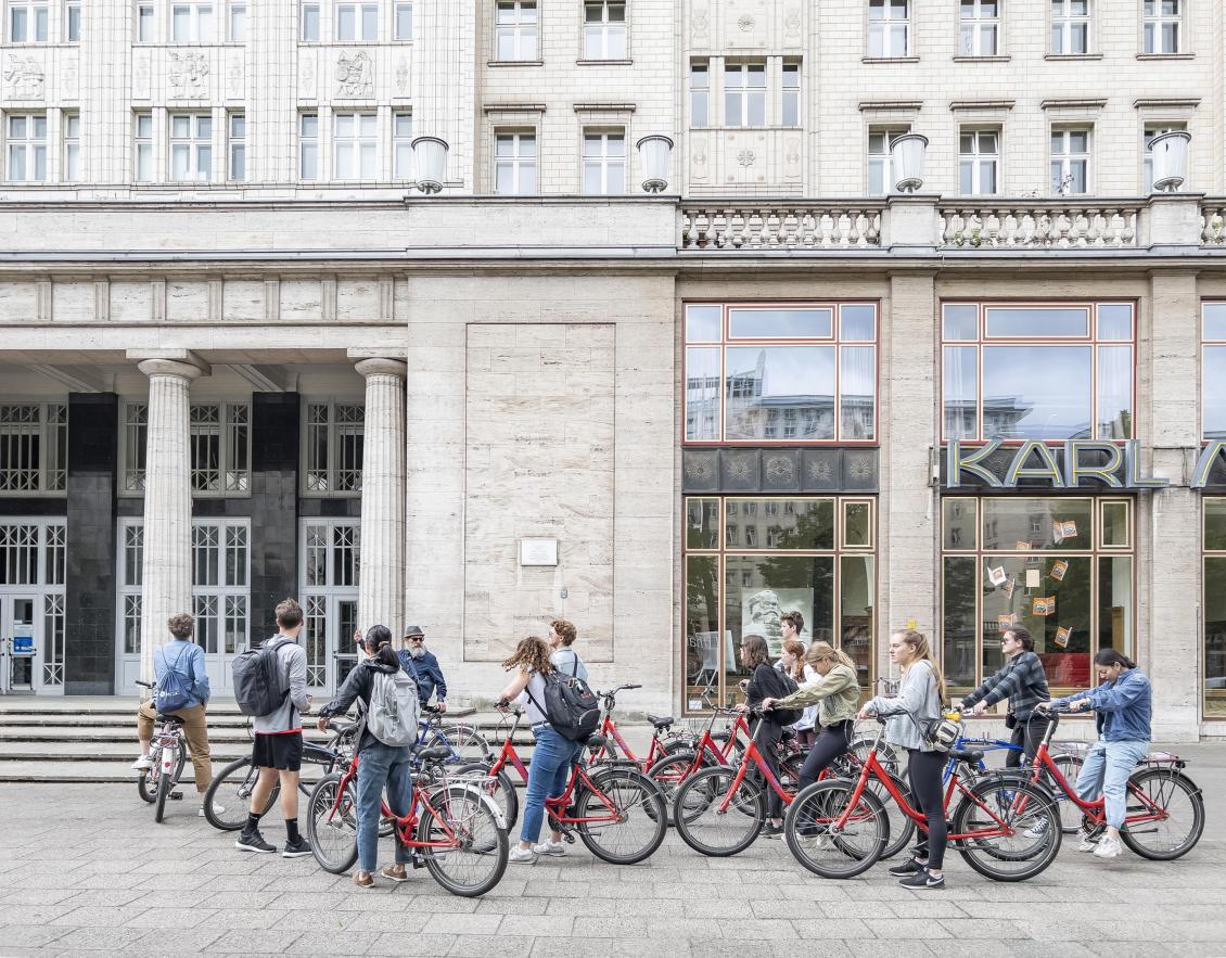 Students discuss mixed-used development and transportation infrastructure along the Karl-Marx-Allee during a biking tour of Berlin.