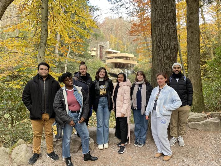 Members of the Knowlton Nomads stand before the Fallingwater house. 